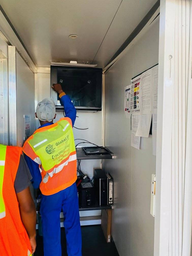 Global IT Systems technicians installing and patching equipment in a network cabinet