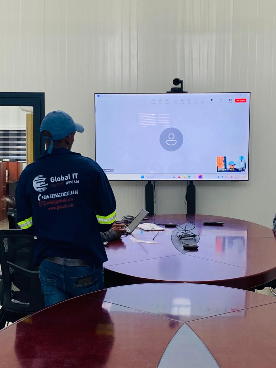 Global IT Systems technician setting up a boardroom video conferencing system
